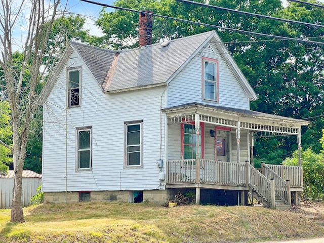 363 Lisbon St, Lisbon, ME 04250 - view of front facade with covered porch, a chimney, a front lawn, and roof with shingles