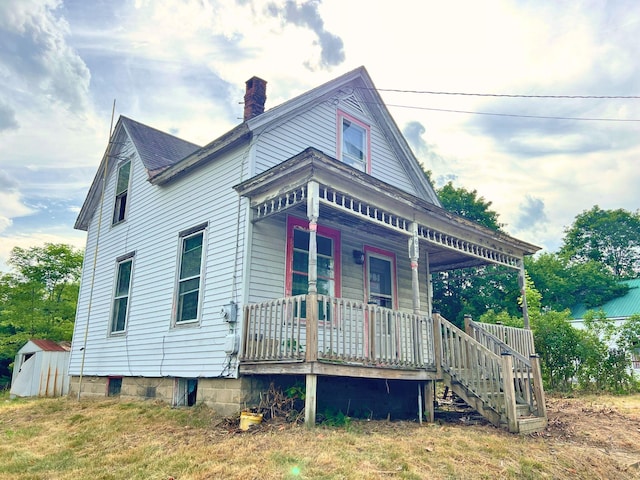 363 Lisbon St, Lisbon, ME 04250 - view of front of home with covered porch, a chimney, and a shed