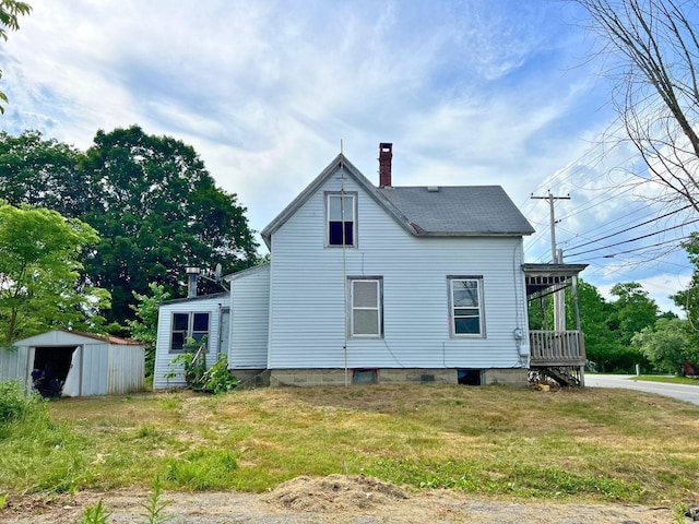 363 Lisbon St, Lisbon, ME 04250 - view of side of home with a chimney, a lawn, and an outdoor structure