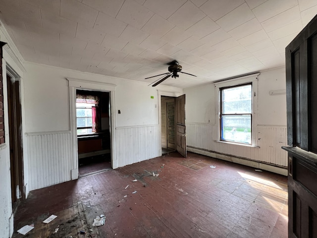 363 Lisbon St, Lisbon, ME 04250 - unfurnished bedroom featuring a wainscoted wall, a baseboard heating unit, hardwood / wood-style floors, and ceiling fan