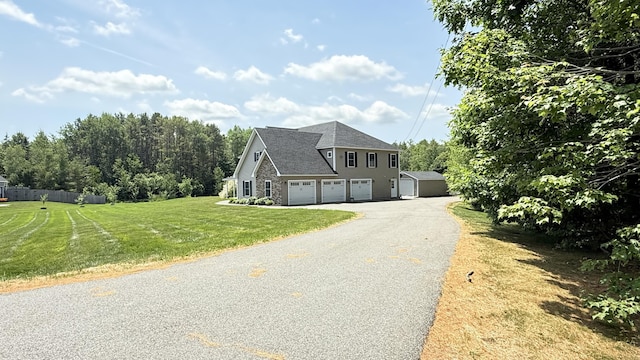 8 Clark Cir, Hampden, ME 04444 - view of front of house with driveway, a garage, stone siding, and roof with shingles