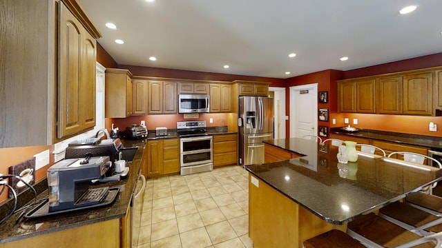 8 Clark Cir, Hampden, ME 04444 - kitchen with appliances with stainless steel finishes, a kitchen bar, recessed lighting, a kitchen island, and dark stone counters