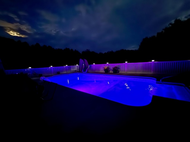 8 Clark Cir, Hampden, ME 04444 - pool at night with a water slide and a fenced backyard
