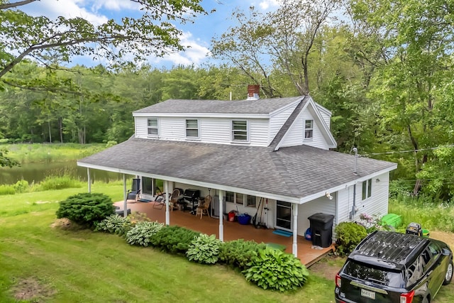 350 Cushing Rd, Cushing, ME 04563 - back of house featuring a shingled roof, a lawn, and a chimney