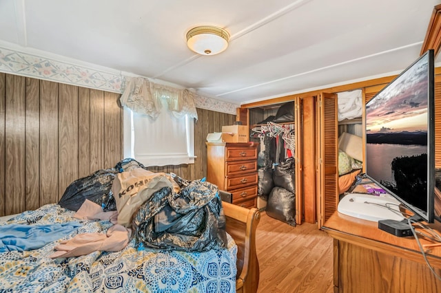350 Cushing Rd, Cushing, ME 04563 - bedroom with light wood-type flooring, wooden walls, and a closet