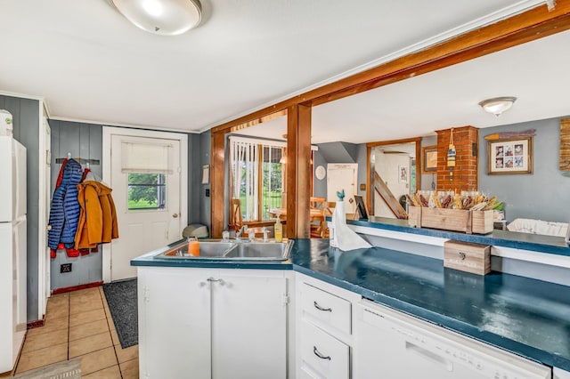 350 Cushing Rd, Cushing, ME 04563 - kitchen featuring white dishwasher, white cabinets, light tile patterned floors, dark countertops, and a peninsula