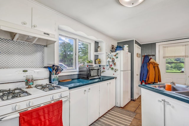 350 Cushing Rd, Cushing, ME 04563 - kitchen featuring white appliances, white cabinetry, under cabinet range hood, light tile patterned floors, and dark countertops
