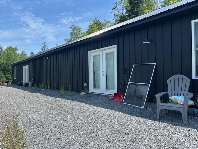 42 Applehead Way, Orrington, ME 04474 - rear view of property with board and batten siding, a metal roof, and french doors