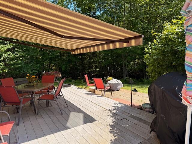 12 Doe Ct Unit 12, Naples, ME 04055 - wooden terrace featuring outdoor dining area, area for grilling, and view of wooded area