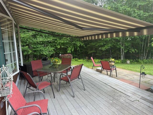 12 Doe Ct Unit 12, Naples, ME 04055 - wooden deck featuring outdoor dining area and a lawn