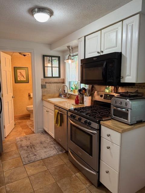 12 Doe Ct Unit 12, Naples, ME 04055 - kitchen featuring stainless steel appliances, decorative backsplash, white cabinets, a textured ceiling, and light countertops