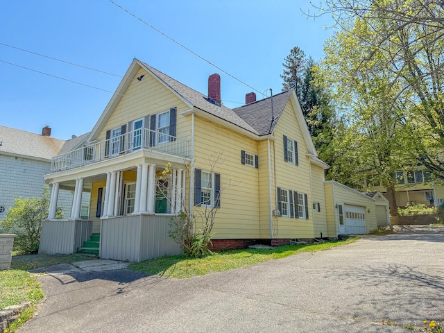 35 Washington St, Rumford, ME 04276 - view of front of home featuring a balcony, a porch, a chimney, a garage, and a shingled roof
