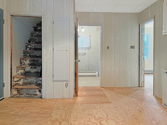 35 Washington St, Rumford, ME 04276 - stairway featuring a baseboard heating unit, a baseboard radiator, wood walls, and wood finished floors