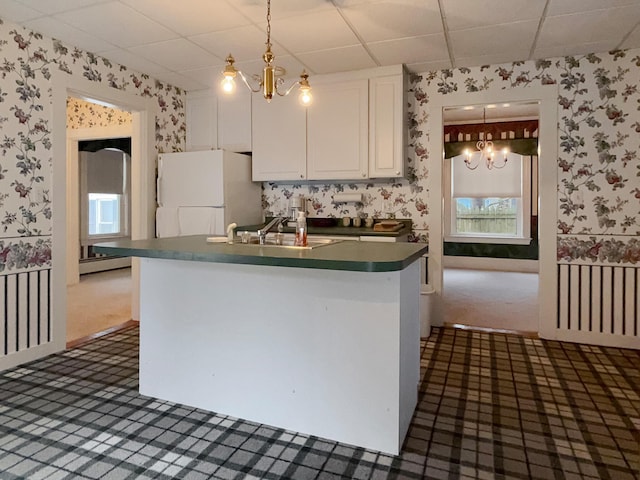 35 Washington St, Rumford, ME 04276 - kitchen with wallpapered walls, freestanding refrigerator, dark colored carpet, a paneled ceiling, and dark countertops