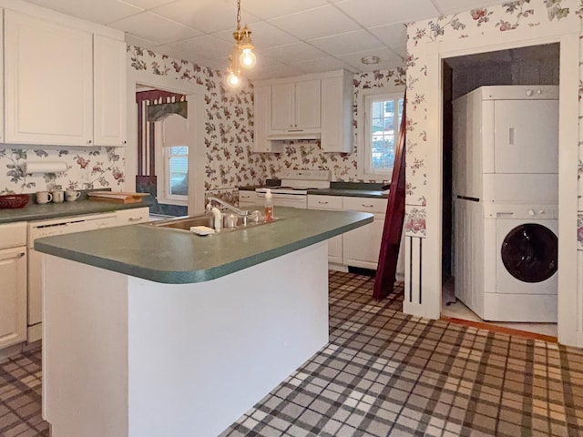 35 Washington St, Rumford, ME 04276 - kitchen with wallpapered walls, white electric stove, a drop ceiling, dark countertops, and stacked washer / dryer
