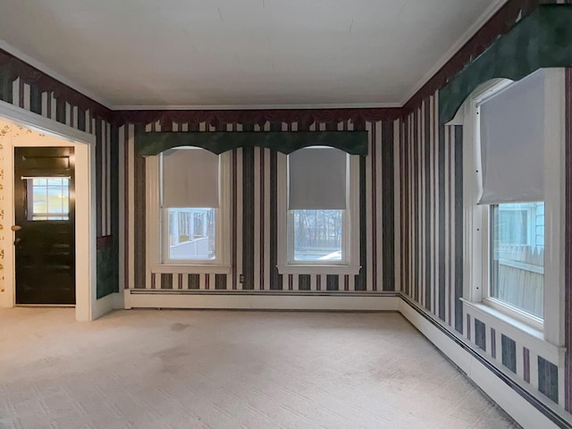 35 Washington St, Rumford, ME 04276 - carpeted empty room featuring a baseboard heating unit, wallpapered walls, and ornamental molding