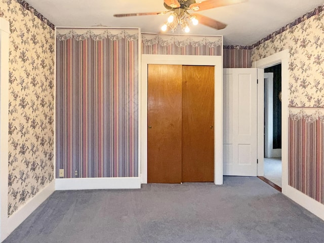 35 Washington St, Rumford, ME 04276 - unfurnished bedroom featuring wallpapered walls, carpet floors, a closet, and a ceiling fan