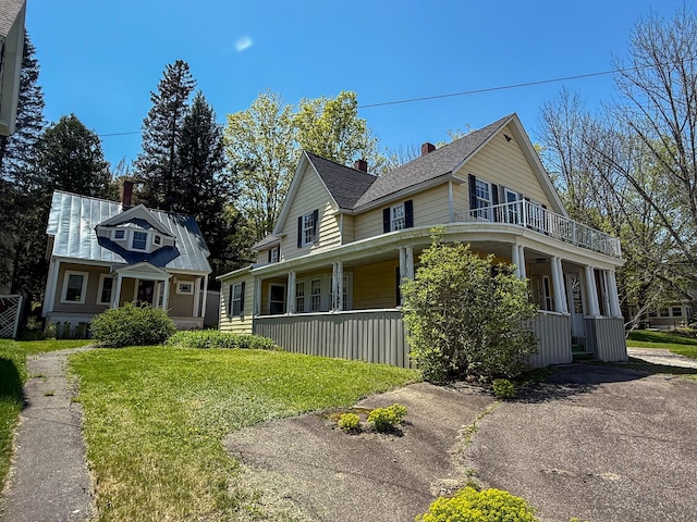 35 Washington St, Rumford, ME 04276 - view of front of property featuring a porch, a front lawn, a balcony, and a chimney
