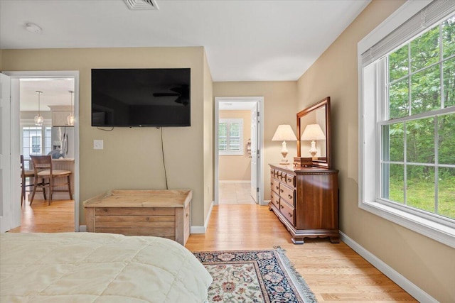 7 Coastal Woods Dr Unit 102, Kennebunk, ME 04043 - bedroom with stainless steel fridge, multiple windows, and light wood-type flooring