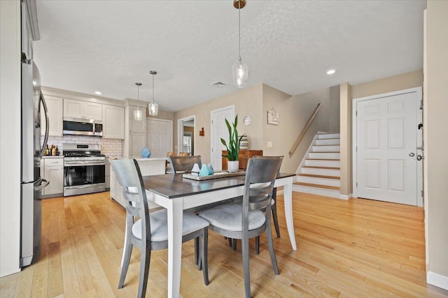 7 Coastal Woods Dr Unit 102, Kennebunk, ME 04043 - dining room with light wood-type flooring, stairs, a textured ceiling, and recessed lighting