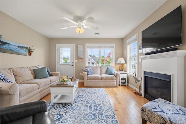 7 Coastal Woods Dr Unit 102, Kennebunk, ME 04043 - living room featuring plenty of natural light, light wood-style flooring, a ceiling fan, and a fireplace