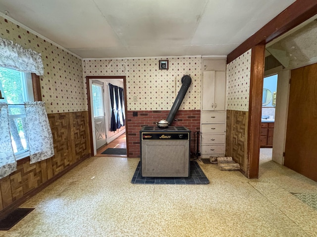 144 Main Rd, Burlington, ME 04417 - kitchen with plenty of natural light, tile patterned floors, wood walls, wallpapered walls, and a wood stove