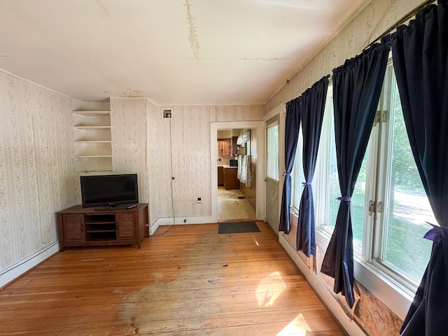 144 Main Rd, Burlington, ME 04417 - unfurnished living room with wallpapered walls, light wood finished floors, and a baseboard heating unit