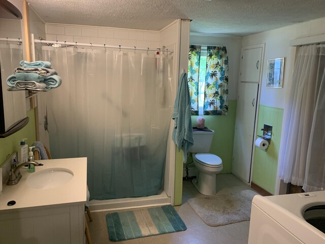 9 Coolidge St, Livermore, ME 04253 - bathroom featuring a stall shower, vanity, a textured ceiling, and washer / clothes dryer