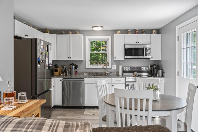 152 Quarry Rd, Limerick, ME 04048 - kitchen with stainless steel appliances, light wood-style flooring, healthy amount of natural light, and white cabinetry