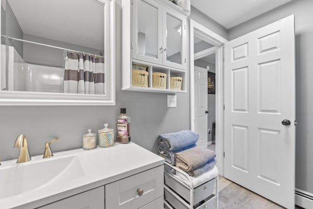 152 Quarry Rd, Limerick, ME 04048 - full bathroom with vanity, a baseboard radiator, wood finished floors, and curtained shower