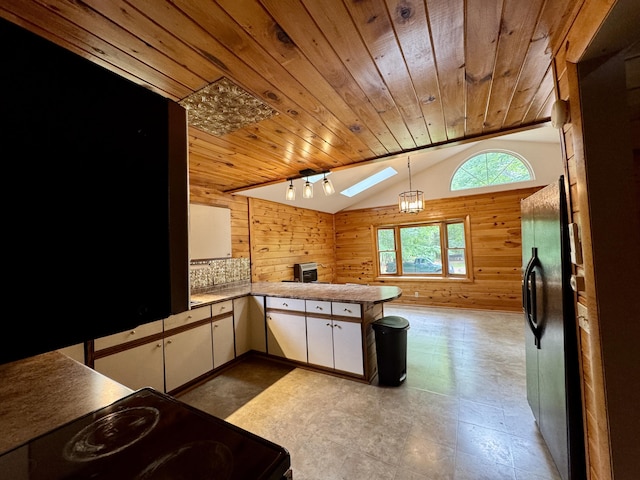 24 N Tiery St, Old Town, ME 04468 - kitchen with wooden walls, vaulted ceiling, wooden ceiling, a peninsula, and black appliances