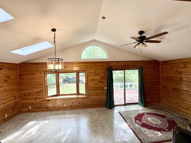 24 N Tiery St, Old Town, ME 04468 - unfurnished room with a skylight, wooden walls, vaulted ceiling, a chandelier, and ceiling fan