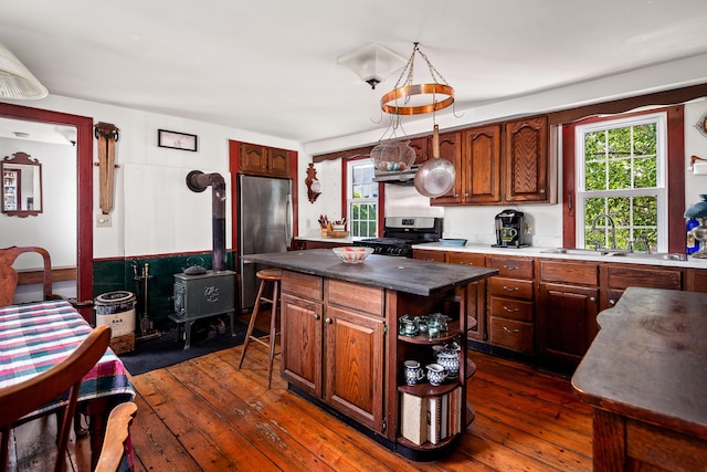 5 Chestnut St, Vinalhaven, ME 04863 - kitchen with range, freestanding refrigerator, a wood stove, and dark wood-style floors