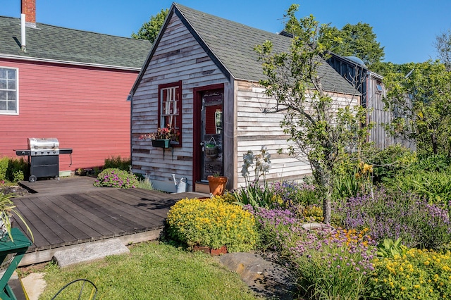 5 Chestnut St, Vinalhaven, ME 04863 - view of front of property with a deck, roof with shingles, a chimney, and an outdoor structure