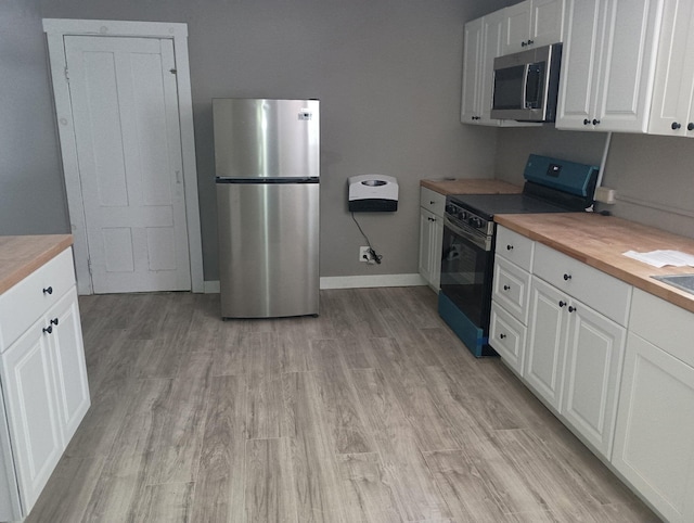 44 Baldwin St, Livermore Falls, ME 04254 - kitchen featuring appliances with stainless steel finishes, wood counters, white cabinetry, and light wood finished floors