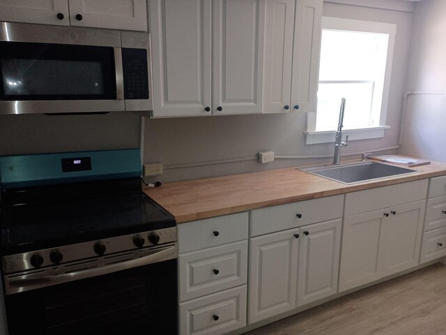 44 Baldwin St, Livermore Falls, ME 04254 - kitchen with appliances with stainless steel finishes, wood counters, white cabinets, and light wood finished floors