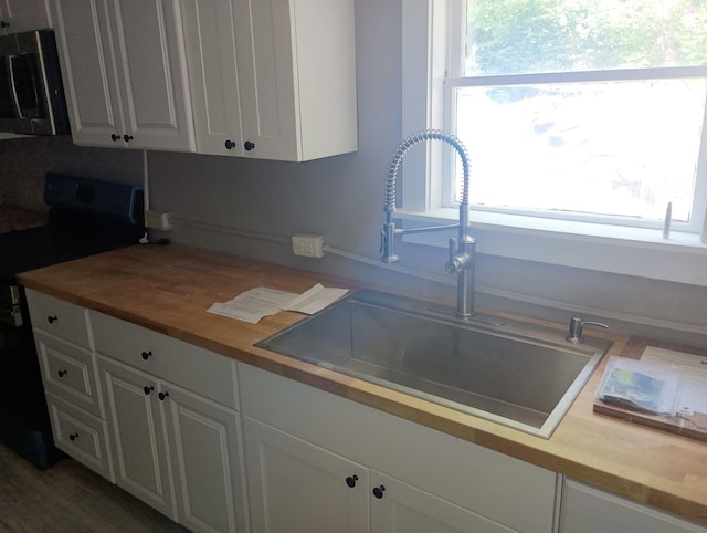 44 Baldwin St, Livermore Falls, ME 04254 - kitchen featuring range with electric cooktop, wooden counters, stainless steel microwave, and white cabinets
