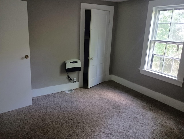 44 Baldwin St, Livermore Falls, ME 04254 - unfurnished bedroom featuring multiple windows and carpet flooring
