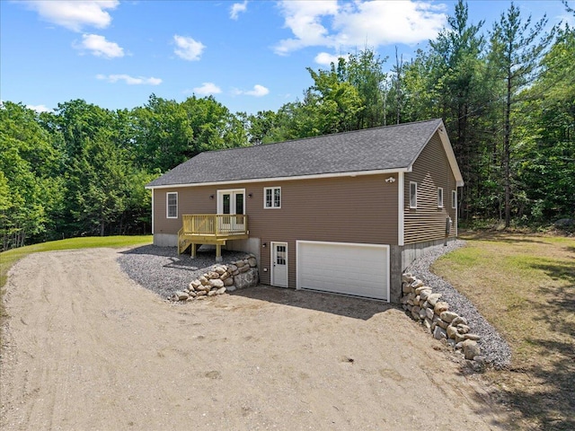 34 Oak Woods Dr, Hiram, ME 04041 - view of front facade featuring driveway, an attached garage, a wooden deck, and roof with shingles
