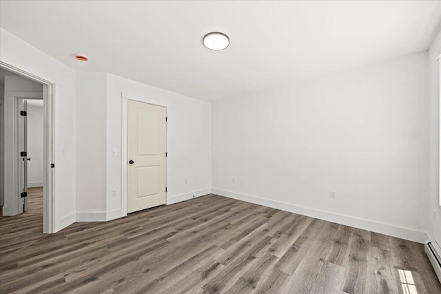 34 Oak Woods Dr, Hiram, ME 04041 - empty room with wood finished floors and a baseboard heating unit