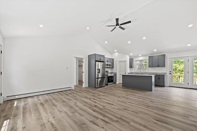 34 Oak Woods Dr, Hiram, ME 04041 - unfurnished living room featuring a baseboard heating unit, a ceiling fan, recessed lighting, lofted ceiling, and light wood finished floors
