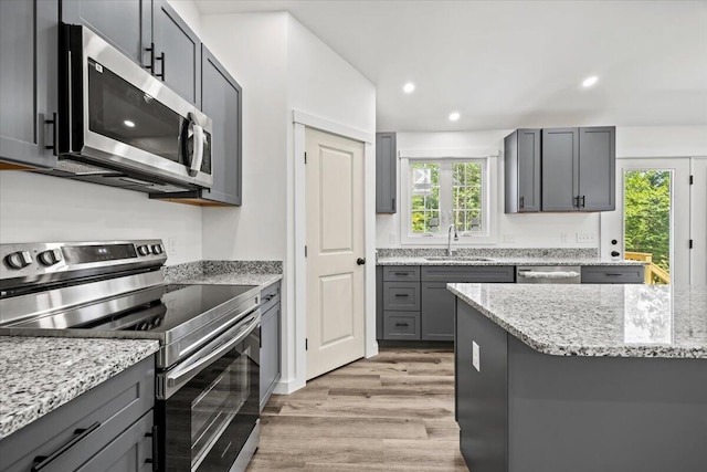 34 Oak Woods Dr, Hiram, ME 04041 - kitchen featuring appliances with stainless steel finishes, light wood-style floors, gray cabinetry, recessed lighting, and light stone counters