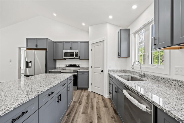 34 Oak Woods Dr, Hiram, ME 04041 - kitchen with appliances with stainless steel finishes, lofted ceiling, light stone countertops, wood finished floors, and gray cabinetry