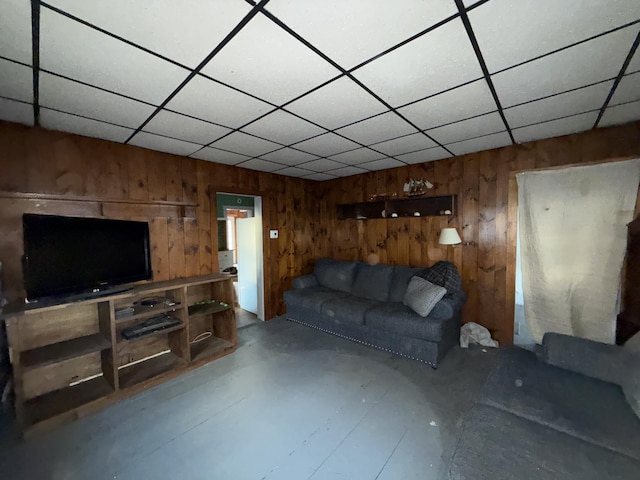 297 Long Beach Ave, York, ME 03909 - unfurnished living room featuring a drop ceiling, wood walls, and concrete floors