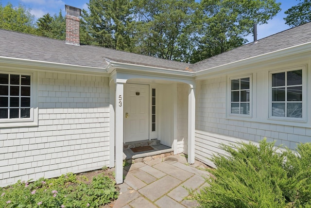 53 Beach Ave, Kennebunk, ME 04043 - doorway to property featuring roof with shingles and a chimney