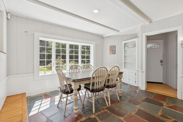 53 Beach Ave, Kennebunk, ME 04043 - dining room featuring beamed ceiling, a decorative wall, and stone finish floors