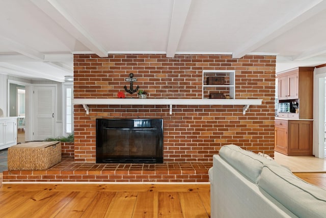 53 Beach Ave, Kennebunk, ME 04043 - detailed view of beamed ceiling, a brick fireplace, and wood finished floors
