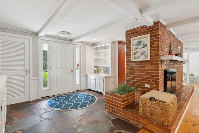 53 Beach Ave, Kennebunk, ME 04043 - entrance foyer with stone floors, beam ceiling, and a fireplace