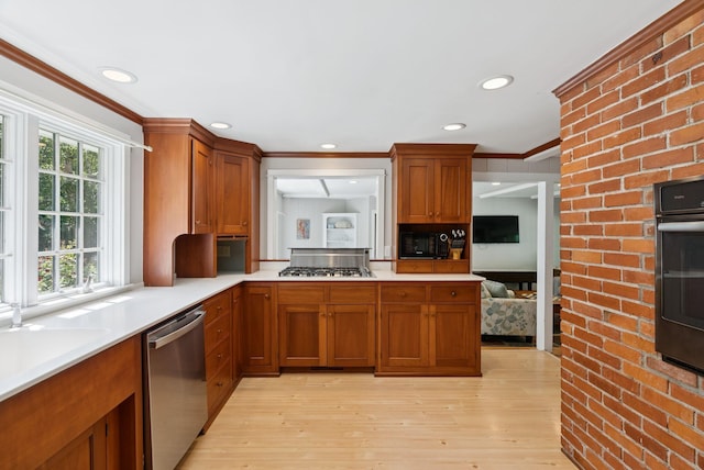 53 Beach Ave, Kennebunk, ME 04043 - kitchen with black appliances, light countertops, brown cabinets, light wood-type flooring, and ornamental molding