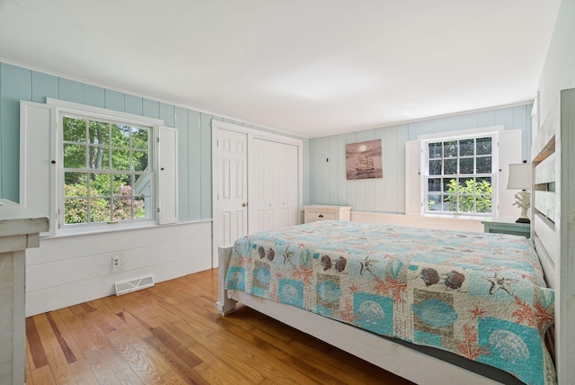 53 Beach Ave, Kennebunk, ME 04043 - bedroom featuring wood finished floors, multiple windows, a closet, and wooden walls